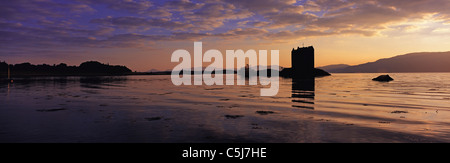 Vivid coucher de soleil sur le son de Shuna et Château de Stalker sur son rocher, Appin, Argyll, les Highlands écossais, au Royaume-Uni. Banque D'Images