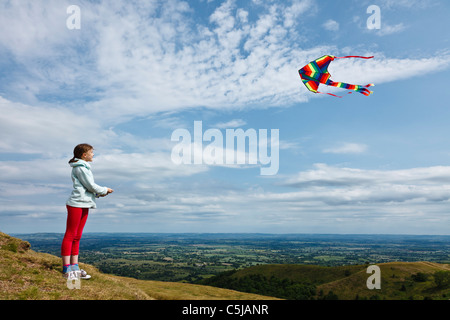 Girl flying kite camp britannique à l'âge de fer fort dans les collines de Malvern. Banque D'Images