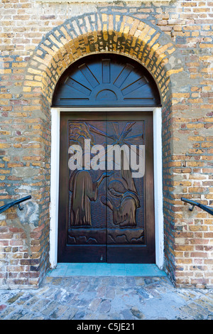 Portes en bois sculpté de Saint John's Anglican Cathedral à Belize City illustrent le baptême de Jésus par Jean le Baptiste. Banque D'Images