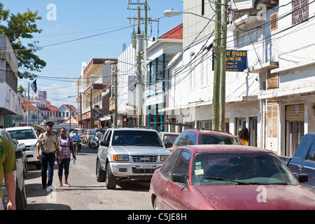 Balades avec femme policier sur encombré street dans le centre-ville de Belize City, Belize Banque D'Images