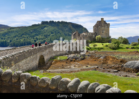 Touristes traversant le pont pour le château d'Eilean Donan, Loch Duich, Highland, Scotland, UK Banque D'Images