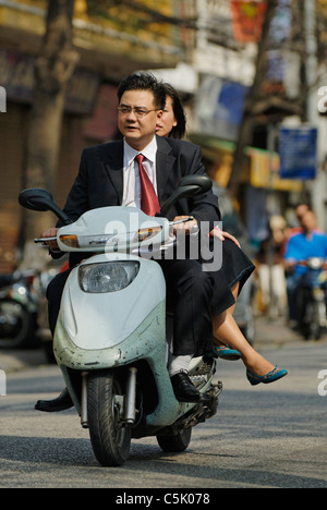 L'Asie, Vietnam, Hanoi. Vieux quartier de Hanoi. Smartly dressed couple riding vietnamiens sur une moto à Hanoi. Banque D'Images