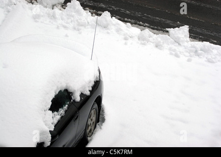 Un véhicule couvert de neige et de neige juste après la ville charrue adoptée l'allée. Banque D'Images