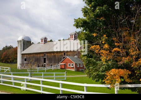 Ancienne grange et silo en automne avec clôture blanche. Banque D'Images