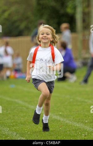 Jeune fille en compétition dans l'exécution de course sur sportsday Banque D'Images