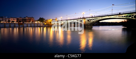 Pont de Triana et à la tombée de la rue Betis avec éclairage décoratif pour la Vela festival, Séville, Espagne Banque D'Images