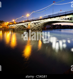 Pont de Triana au crépuscule avec éclairage décoratif pour la Vela festival, Séville, Espagne Banque D'Images