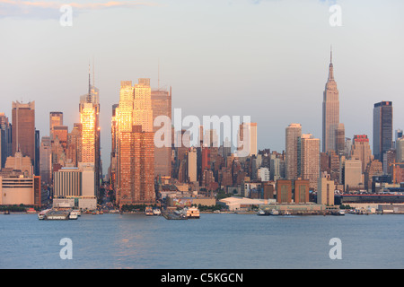 Le soleil couchant se reflète dans les fenêtres des gratte-ciel de Manhattan, sur la 42e rue, comme vu sur le fleuve Hudson, du New Jersey Banque D'Images