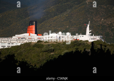 Un paquebot de croisière Queen Elizabeth II de quitter le port de Wellington ; observer les gens en premier plan Banque D'Images