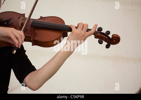 Les mains et bras gauche de jeune femme jouant du violon, close-up Banque D'Images