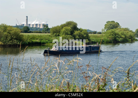 Un bateau étroit, voyageant la rivière Trent, avec Ratcliffe-on-Soar power station en arrière-plan Banque D'Images