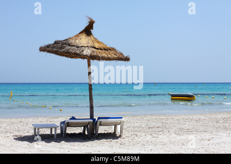 Parasol et transats inclinée sur une plage de sable fin Banque D'Images
