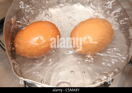 Deux oeufs dans une casserole bouillante. Banque D'Images