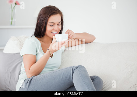 Cute dark-haired woman drinking tea Banque D'Images