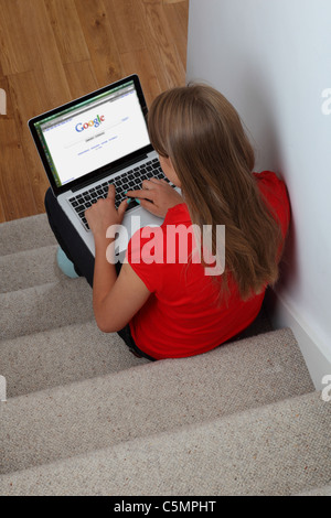 Jeune fille à l'aide de l'ordinateur portable sur le moteur de recherche Google. Banque D'Images