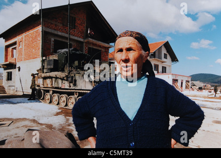 Une famille de Serbes de Bosnie retourne dans leur ancienne maison près de Mrkonjic Grad, alors que des armes à feu sont placées à proximité de l'Europe Banque D'Images