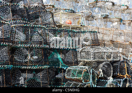 Des casiers à crabe et homard empilés sur le quai au port de Brixham Devon, Angleterre. Banque D'Images