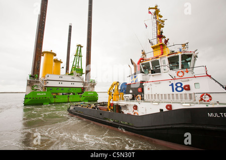 Le cric l'barge, Goliath, remorqué par un remorqueur, à l'éolien offshore Walney pour installer des pièces de transition de l'éolienne. Banque D'Images