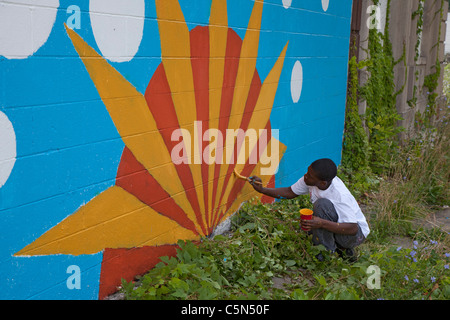 Detroit, Michigan - les bénévoles de l'école secondaire de la peinture sur un bâtiment vide. Ils travaillent tout l'été dans la ville programme. Banque D'Images