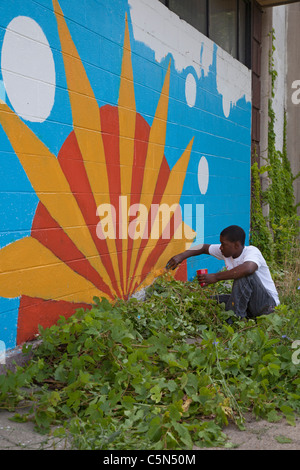 Detroit, Michigan - les bénévoles de l'école secondaire de la peinture sur un bâtiment vide. Ils travaillent tout l'été dans la ville programme. Banque D'Images