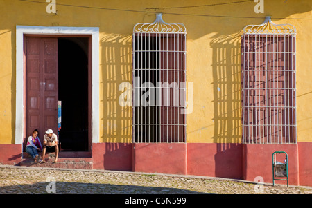 Cuba, Trinidad. Couple assis sur une porte. Banque D'Images