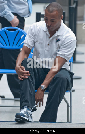 Ancien britannique Colin Jackson sprint et haies met sur chaussure de course St Pancras International Jeux Olympiques 2012 Banque D'Images