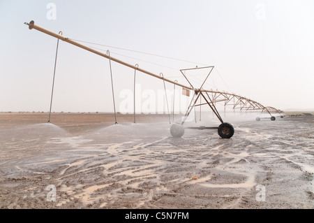 Un centre d'énergie solaire Système d'irrigation à pivot pulvériser de l'eau dans le désert de l'Est du Royaume hachémite de Jordanie. Banque D'Images