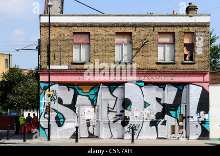 La scène de rue de l'est de Londres a échoué business redondant fermé vandalisé et monté dans un bâtiment de pub couvert de Street art graffiti Angleterre Royaume-Uni Banque D'Images