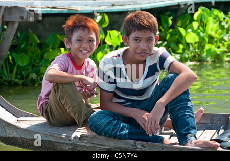 Deux garçons sur un bateau dans le village flottant de Kompong Chnang au Cambodge Banque D'Images