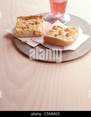 Deux morceaux de tarte à l'oignon avec du bacon sur une plaque de bois Banque D'Images