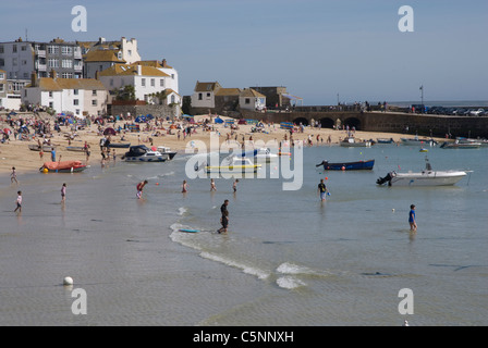 Personnes pagayant à marée montante sur la plage du Port, St Ives Cornwall England UK Banque D'Images