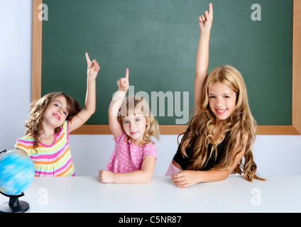 Enfants filles intelligent étudiant en groupe classe raising hand doigt avec tableau noir Banque D'Images