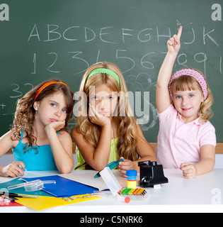 Triste ennuyeux avec l'élève les enfants clever girl raising hand collés à l'école de classe Banque D'Images