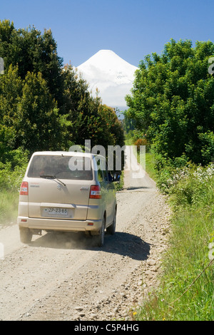 Voiture sur une route de gravier, en face de la région de Lakeland, volcan Osorno, Chili, Amérique du Sud Banque D'Images