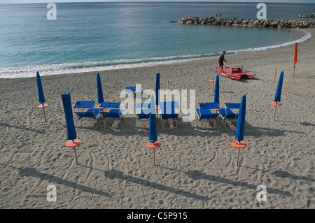 Les transats et parasols sont alignés soigneusement sur la plage, tôt le matin avant l'heure de la plage, avec de longues ombres. Banque D'Images