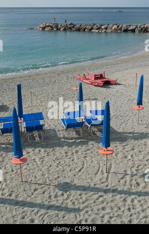 Les transats et parasols sont alignés soigneusement sur la plage, tôt le matin avant l'heure de la plage, avec de longues ombres. Banque D'Images