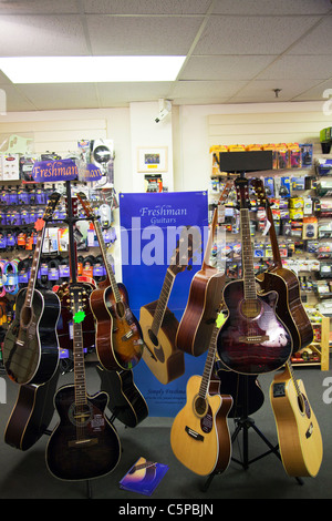 Nouveau support de guitare dans un magasin de musique guitares montrant pour la vente au public sur l'écran acoustique & électrique Banque D'Images