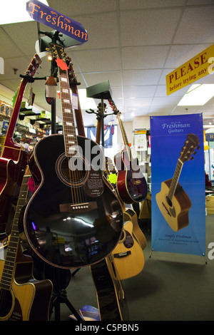 Nouveau support de guitare dans un magasin de musique guitares montrant pour la vente au public sur l'écran acoustique & électrique Banque D'Images