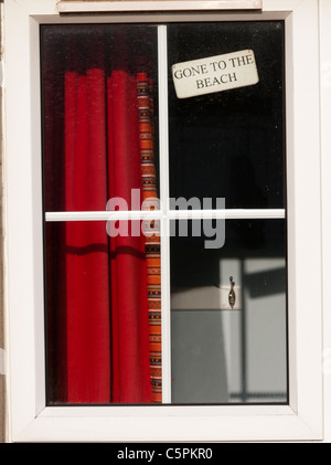 Allé à la plage ouvrir la fenêtre d'une maison de vacances. Banque D'Images