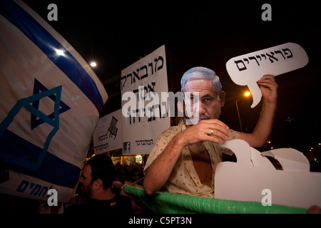 Un manifestant porte un masque au Premier ministre israélien Benyamin Netanyahou lorsqu'il proteste contre la hausse des prix de l'immobilier à tel Aviv. La manifestation de justice sociale, également appelée manifestation de Tents, était une série de manifestations en Israël à partir de juillet 2011 impliquant des centaines de milliers de manifestants issus de divers milieux socio-économiques opposés à la hausse continue du coût de la vie, en particulier du logement. Banque D'Images