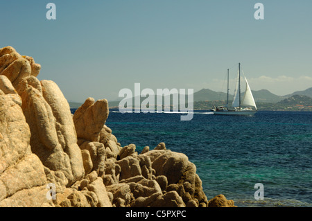 Bateau à voile et les roches de granit jaune sur la rive de la Costa Smeralda Gallura,mer,Sardaigne,Italie Banque D'Images