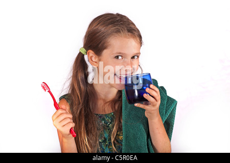 Fillette de huit ans avec une brosse à dents et une serviette pour nettoyer les dents Banque D'Images