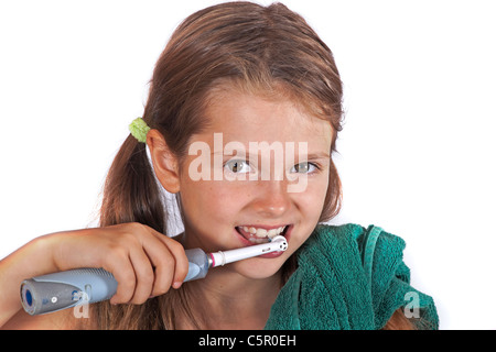 Fillette de huit ans avec une brosse à dents et une serviette pour nettoyer les dents Banque D'Images