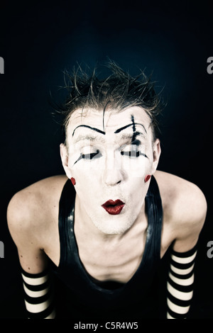 Portrait d'un clown terrible avec un maquillage foncé sur fond noir Banque D'Images