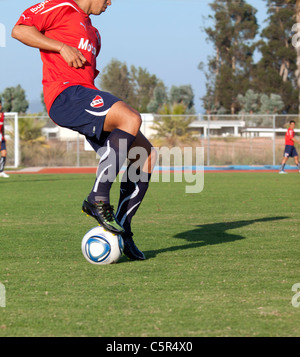 Joueur de football de dribbler le ballon sur le terrain Banque D'Images