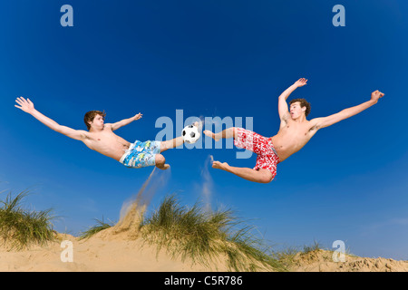 Deux joueurs de football en compétition au milieu de l'air pour le volley ball. Banque D'Images