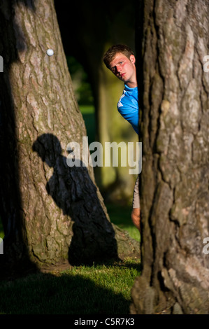 Un golfeur jouant un coup dans les arbres où l'accent sur la balle. Banque D'Images