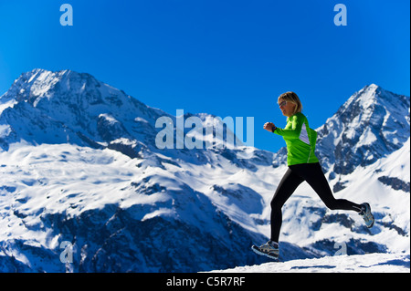 Un ensemble jogging femme montagnes enneigées. Banque D'Images