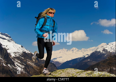 Jogger qui traverse les montagnes enneigées. Banque D'Images