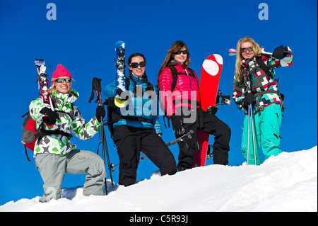 Quatre amis sur un ski et snowboard vacances à s'amuser. Banque D'Images